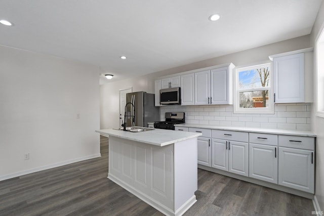 kitchen featuring appliances with stainless steel finishes, dark hardwood / wood-style floors, white cabinetry, and an island with sink