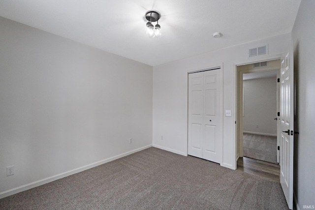 unfurnished bedroom featuring dark colored carpet and a closet