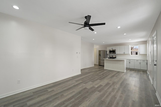 unfurnished living room featuring ceiling fan and wood-type flooring