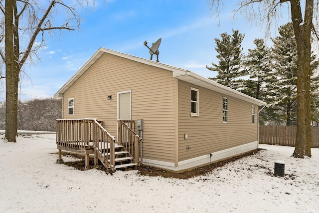 view of snow covered back of property