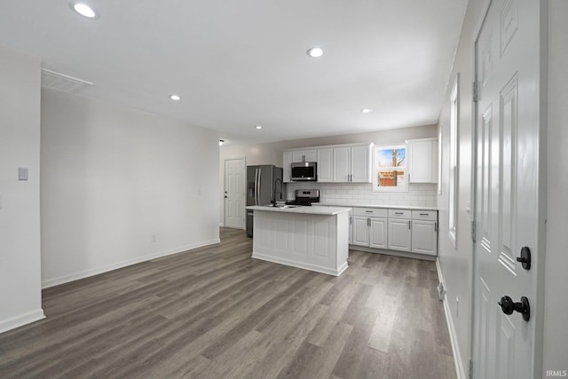 kitchen featuring white cabinets, appliances with stainless steel finishes, a center island, and light wood-type flooring