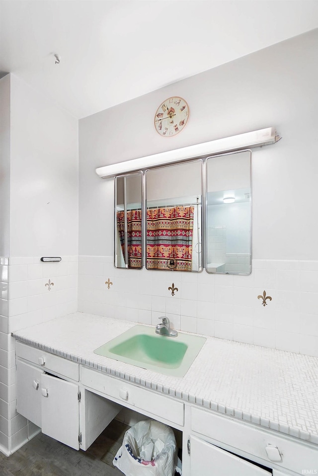 bathroom featuring vanity and tile walls