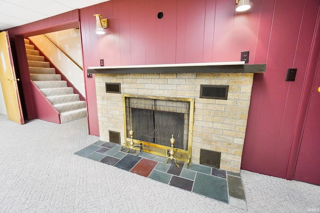 details with wooden walls, a fireplace, and carpet floors