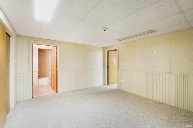 carpeted empty room with a paneled ceiling