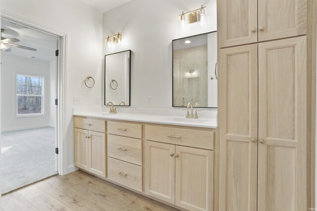 bathroom featuring ceiling fan, vanity, an enclosed shower, and hardwood / wood-style flooring