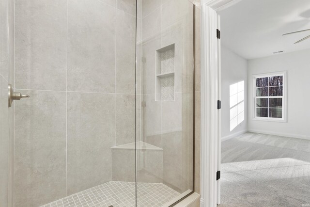 bathroom with ceiling fan and a shower with shower door