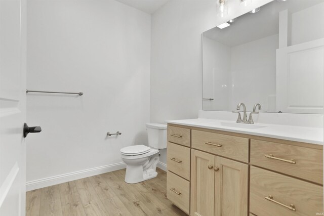 bathroom with vanity, wood-type flooring, and toilet