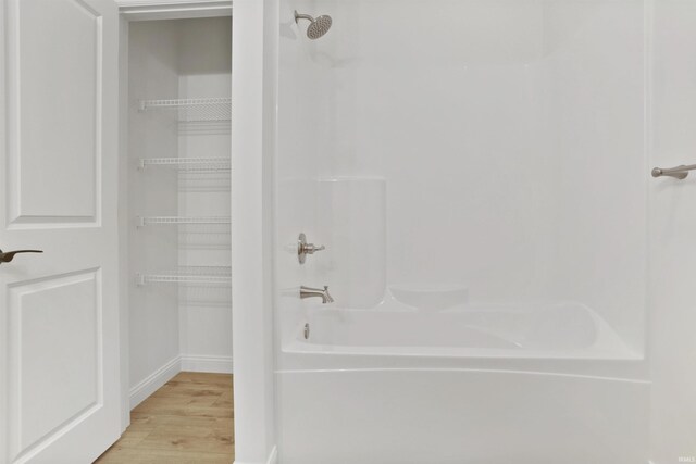 bathroom with shower / bathing tub combination and wood-type flooring