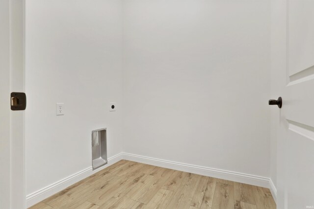 clothes washing area featuring hookup for an electric dryer and light wood-type flooring