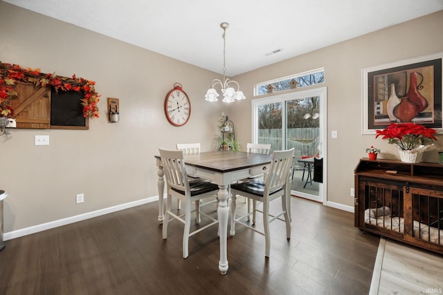 dining area with dark hardwood / wood-style flooring and an inviting chandelier