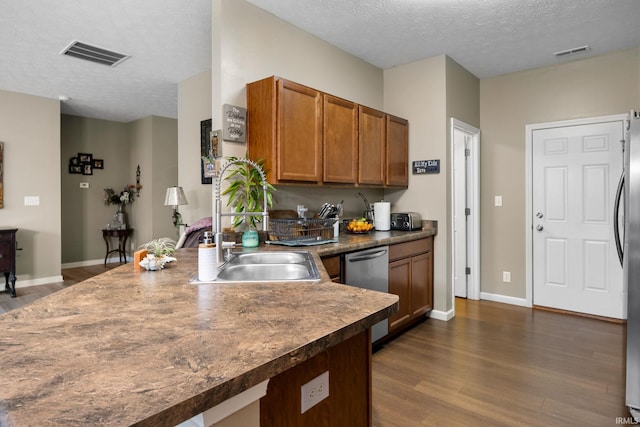 kitchen featuring dark hardwood / wood-style flooring, a textured ceiling, and appliances with stainless steel finishes