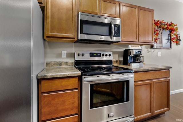 kitchen with hardwood / wood-style floors and appliances with stainless steel finishes