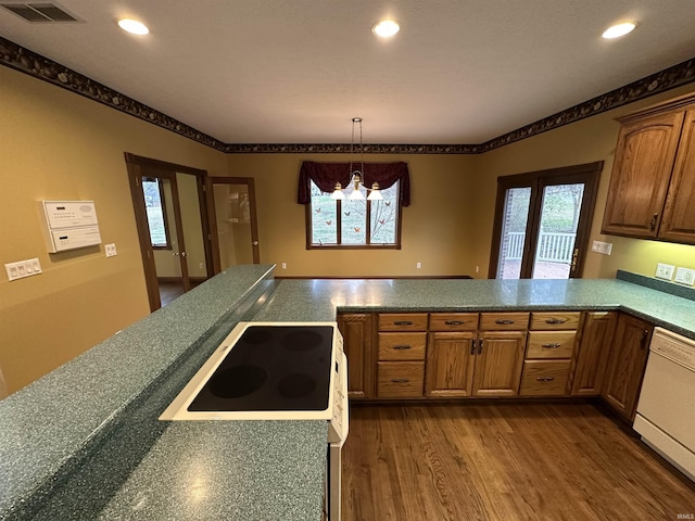 kitchen featuring dishwasher, hanging light fixtures, kitchen peninsula, a chandelier, and hardwood / wood-style flooring