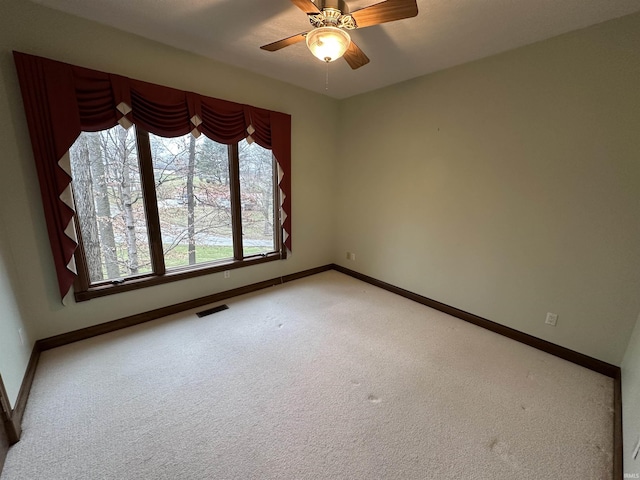 unfurnished room with ceiling fan and light carpet