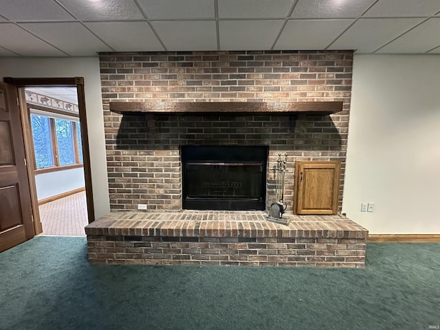 room details with a drop ceiling, carpet floors, and a fireplace