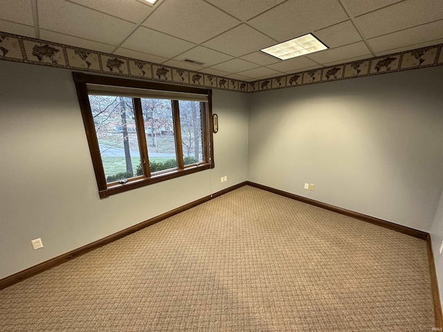 empty room featuring a drop ceiling and carpet floors