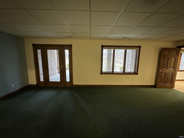 carpeted spare room with a paneled ceiling and plenty of natural light