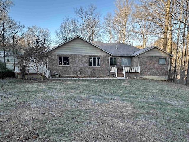 rear view of house featuring a yard and covered porch