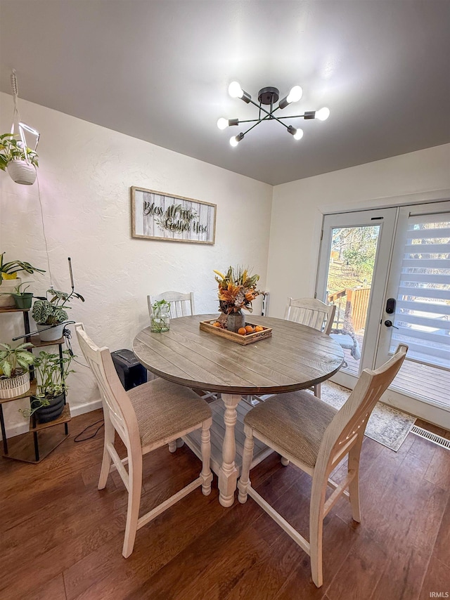 dining area featuring hardwood / wood-style floors and an inviting chandelier