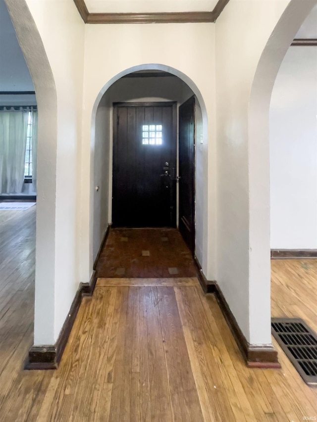 hall featuring hardwood / wood-style floors and crown molding