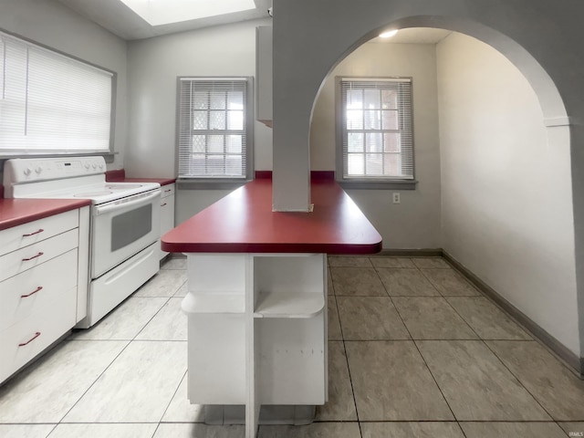 kitchen featuring white cabinets, white electric range oven, and light tile patterned flooring