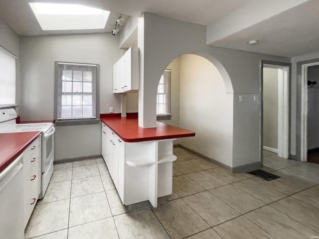 kitchen with kitchen peninsula, white cabinetry, light tile patterned floors, and white appliances