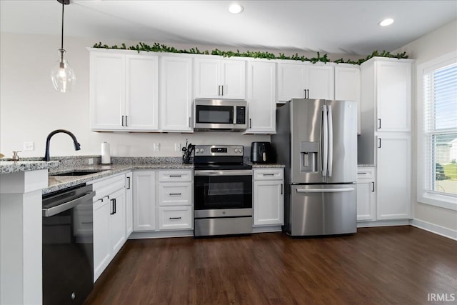 kitchen featuring white cabinetry, light stone countertops, dark hardwood / wood-style floors, decorative light fixtures, and appliances with stainless steel finishes