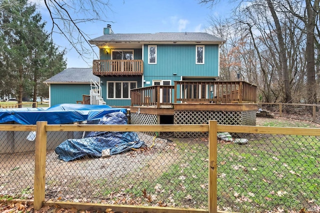 back of house with a pool side deck, a balcony, and a yard