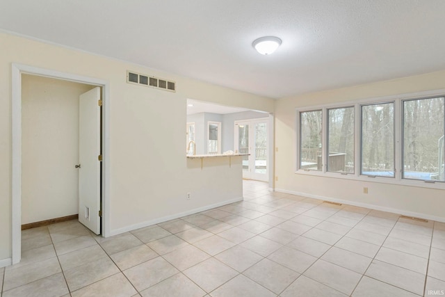 spare room featuring light tile patterned flooring and a textured ceiling