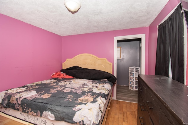 bedroom featuring light hardwood / wood-style floors and a textured ceiling