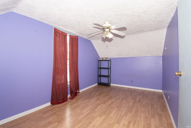 bonus room featuring hardwood / wood-style floors, lofted ceiling, and a textured ceiling