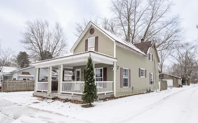 view of front of house with a porch, a garage, and an outbuilding