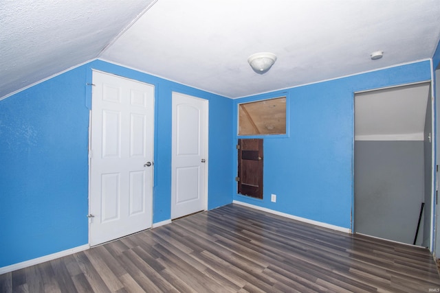 unfurnished bedroom featuring dark hardwood / wood-style floors and lofted ceiling