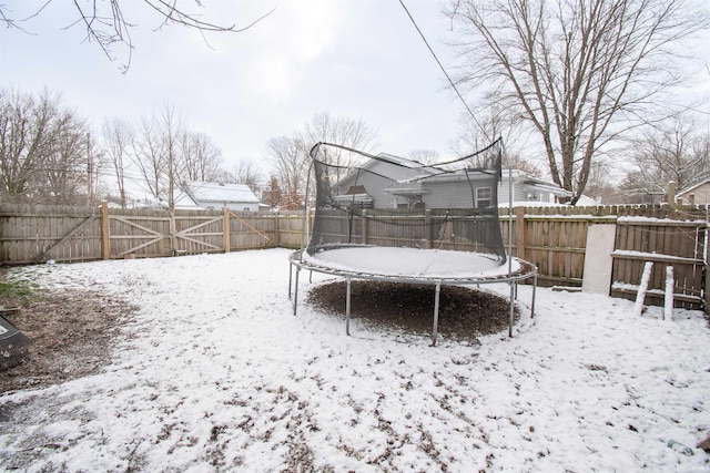 snowy yard featuring a trampoline