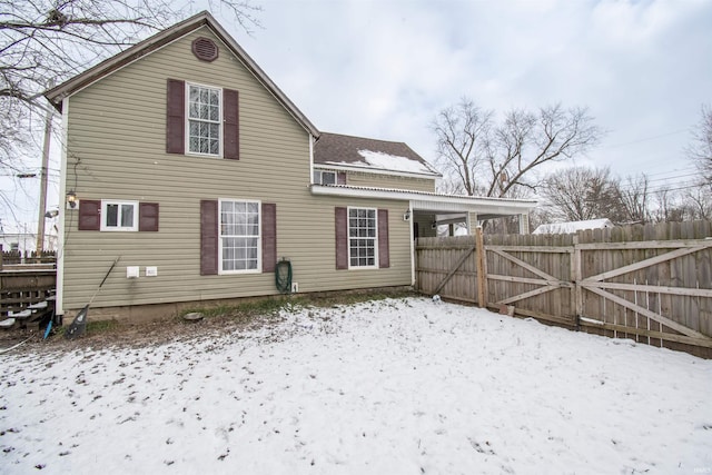 view of snow covered back of property