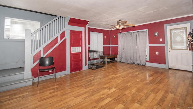 unfurnished living room with ceiling fan, hardwood / wood-style floors, and ornamental molding