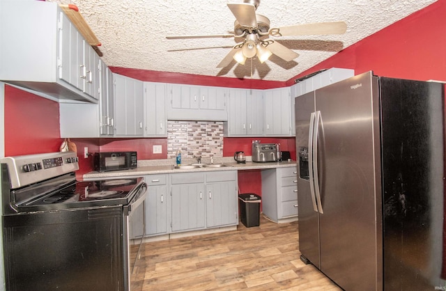 kitchen featuring sink, light hardwood / wood-style flooring, ceiling fan, a textured ceiling, and stainless steel appliances