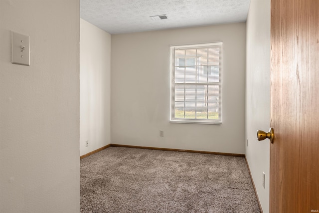 carpeted empty room featuring a textured ceiling