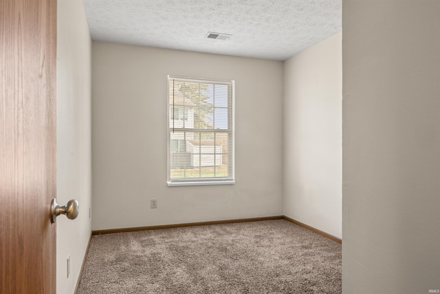 carpeted spare room with a textured ceiling