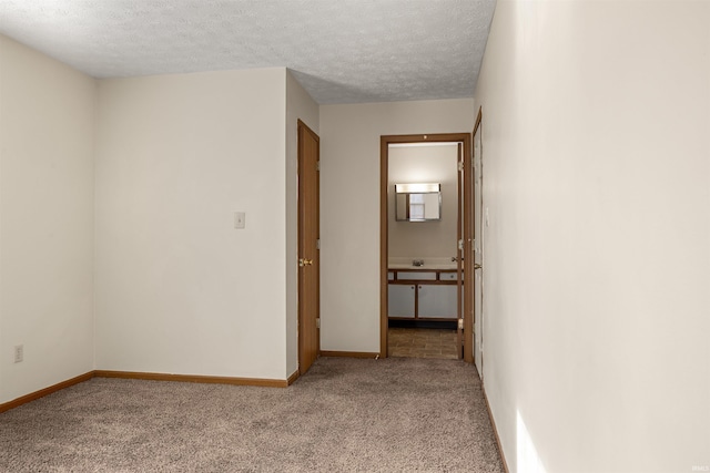 corridor featuring light carpet and a textured ceiling