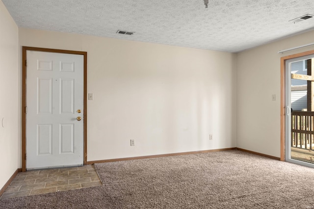 carpeted empty room with a textured ceiling