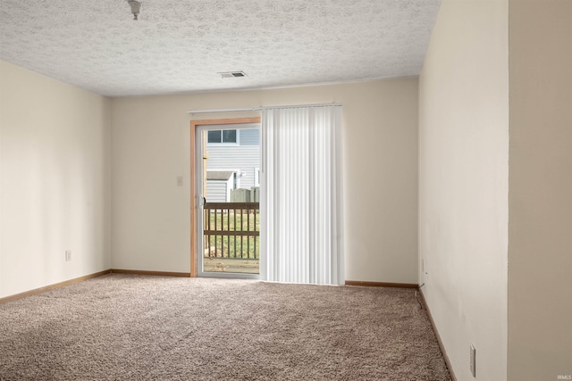 carpeted spare room featuring a textured ceiling