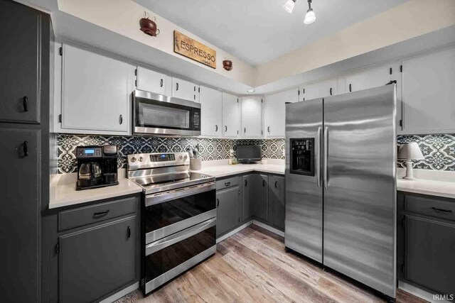 kitchen featuring backsplash, light hardwood / wood-style floors, white cabinetry, and stainless steel appliances