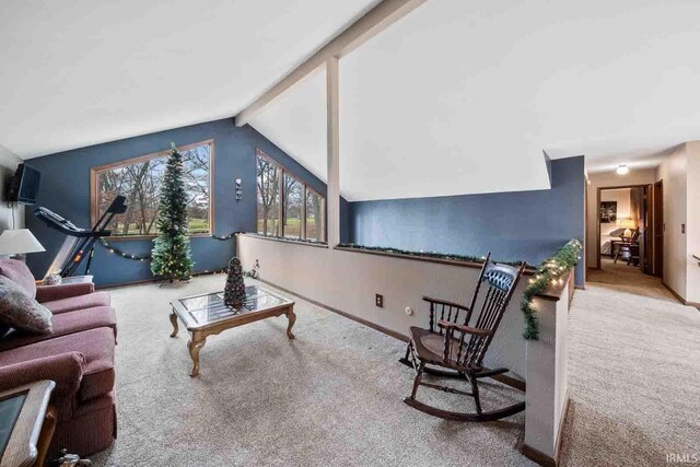 living room with lofted ceiling with beams and light colored carpet