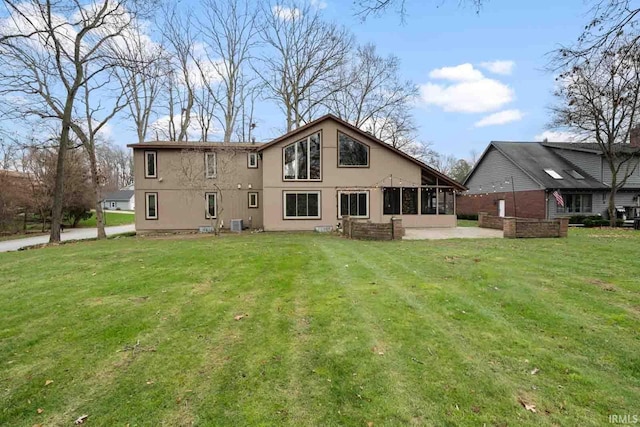 back of house with a lawn and a sunroom