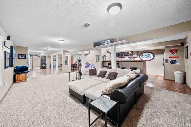 living room featuring bar and a textured ceiling