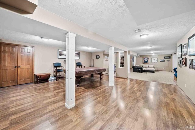 playroom featuring light wood-type flooring, a textured ceiling, and billiards