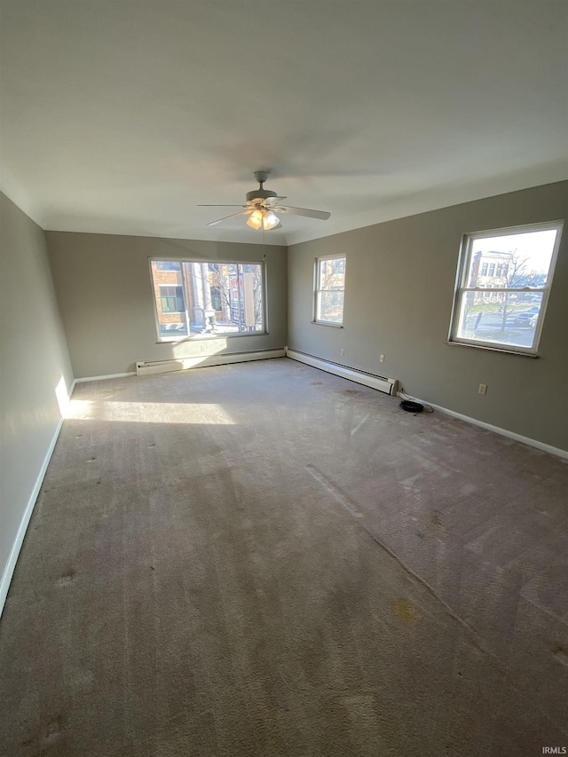 carpeted spare room with ceiling fan and a baseboard radiator