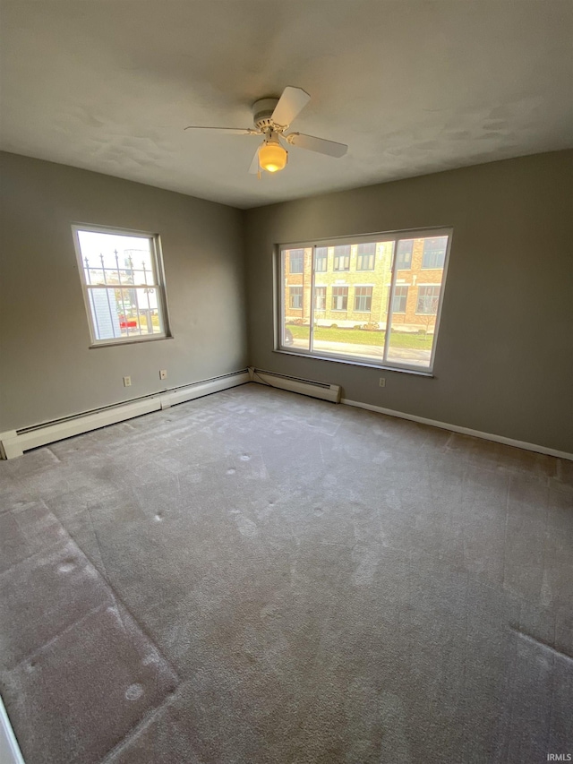 carpeted spare room with a baseboard radiator and ceiling fan