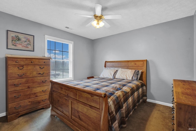 carpeted bedroom featuring ceiling fan and a textured ceiling